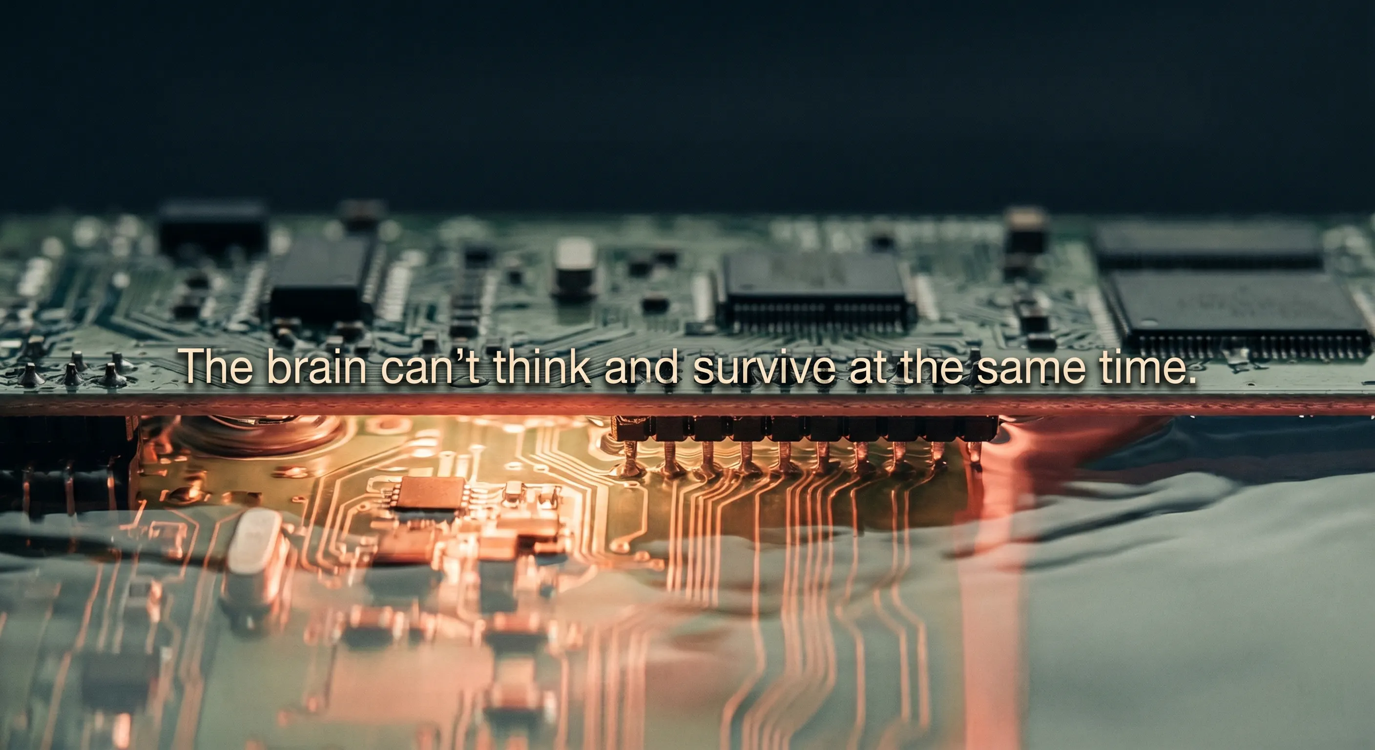 Macro cinematic still of a circuit board half-submerged in calm water, one side lit with warm amber glow representing emotional activation, the other dark and quiet, with text overlay: 'The brain can't think and survive at the same time.'